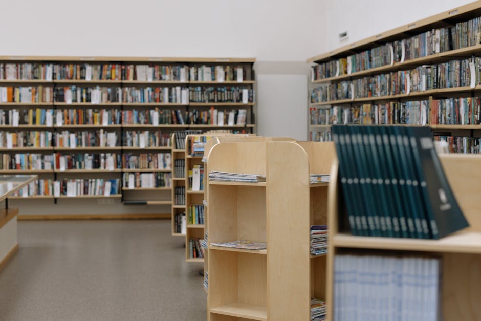 Spacious university library featuring wooden bookshelves filled with diverse books for education and research.